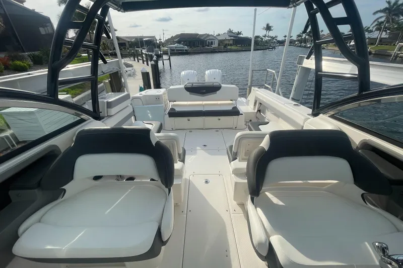 Slide: The Image of 2023 Robalo R317 Dual Console boat interior with seating, docked by waterfront homes. - 12