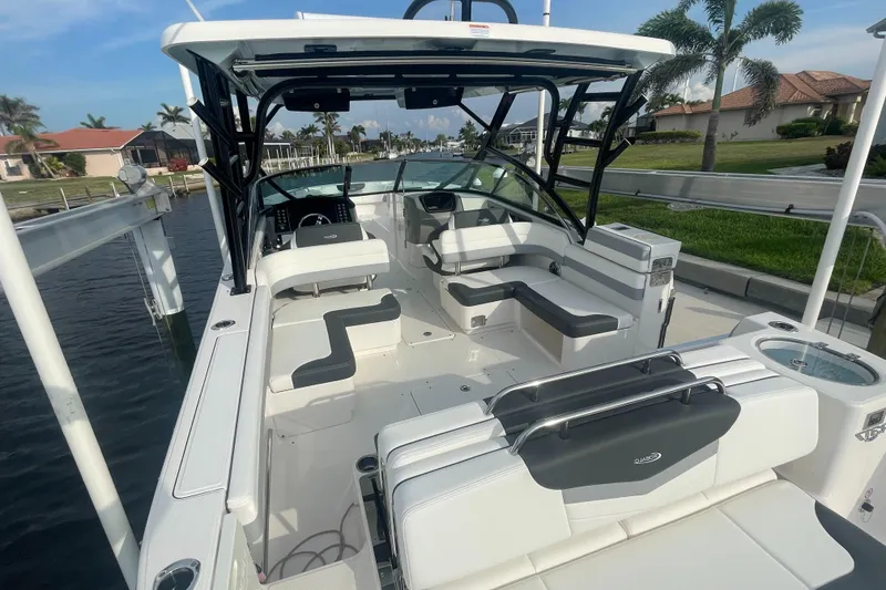 Slide: The Image of 2023 Robalo R317 Dual Console boat with spacious seating, docked near waterfront homes. - 8