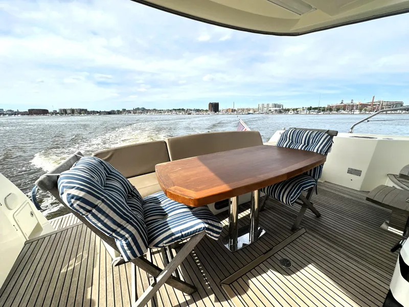 Slide: The Image of Luxury yacht deck with striped chairs and wooden table, Prestige 500, 2013 model, cruising on open water. - 1
