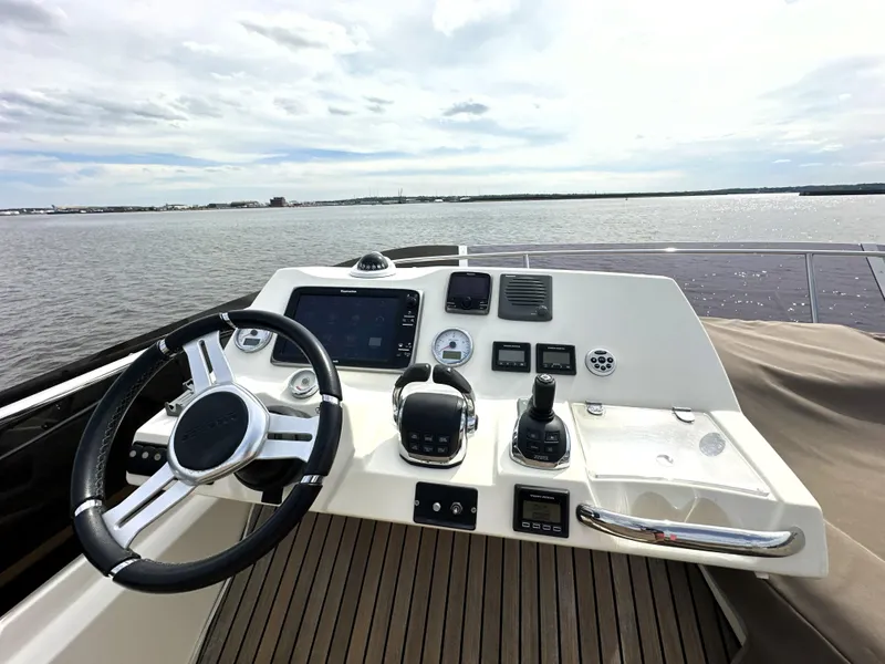Slide: The Image of Helm of 2013 Prestige 500 yacht with steering wheel and control panel on open water. - 13