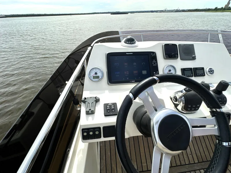 Slide: The Image of Steering console of a 2013 Prestige 500 yacht with navigation controls on open water. - 15
