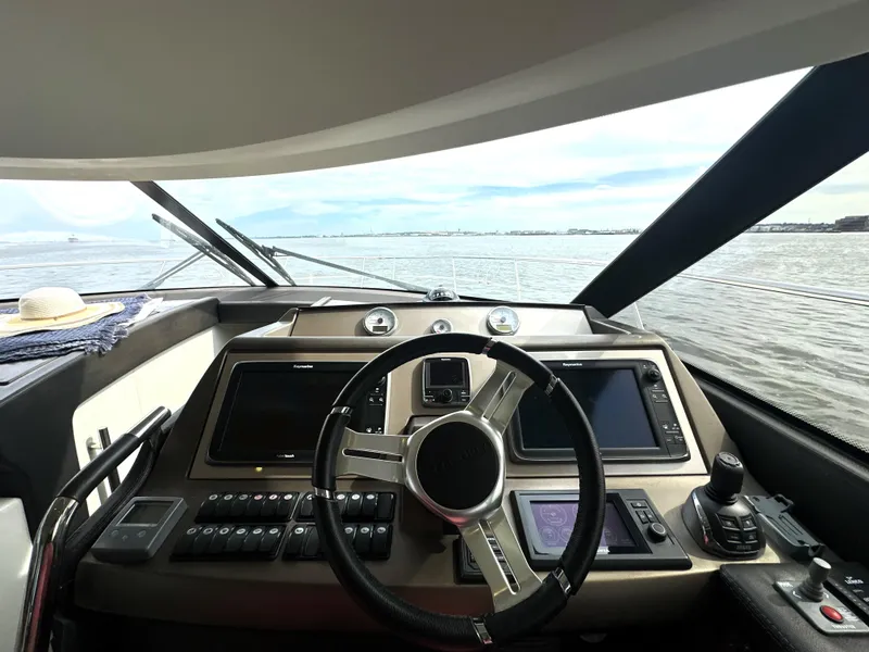 Slide: The Image of Cockpit view of 2013 Prestige 500 yacht with steering wheel and navigation screens. - 27