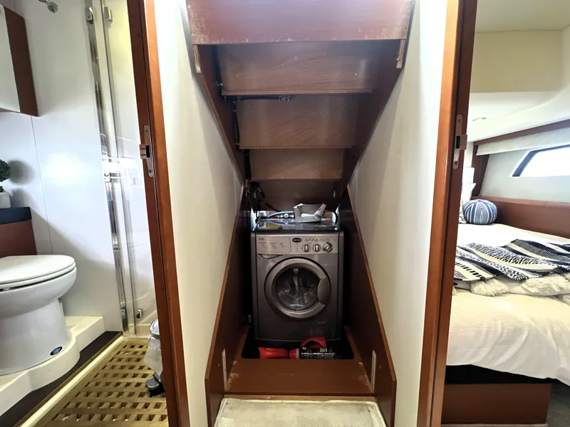 Slide: The Image of Laundry area with washing machine in 2013 Prestige 500 yacht, adjacent to bathroom and bedroom. - 40