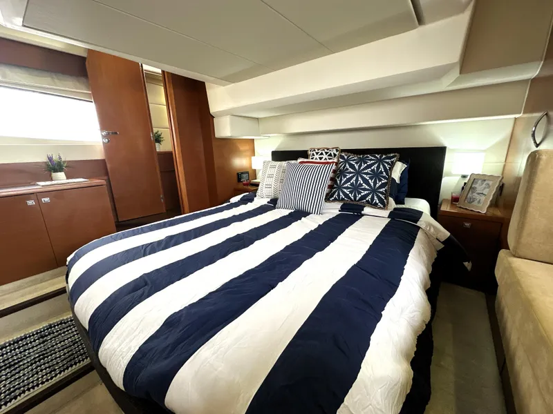 Slide: The Image of Luxurious bedroom interior of a 2013 Prestige 500 yacht with striped bedding. - 44