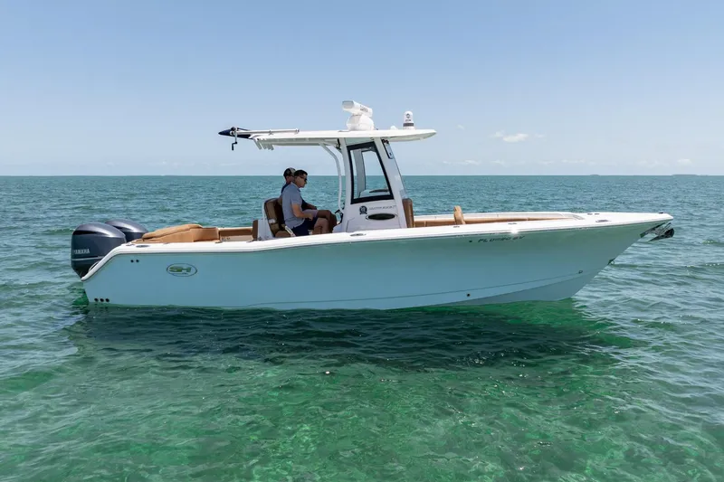 Slide: The Image of 2021 Sea Hunt Ultra 275 SE boat cruising on clear blue water. - 10