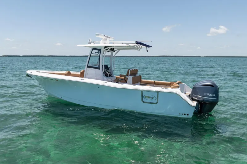 Slide: The Image of 2021 Sea Hunt Ultra 275 SE boat on clear blue water. - 14