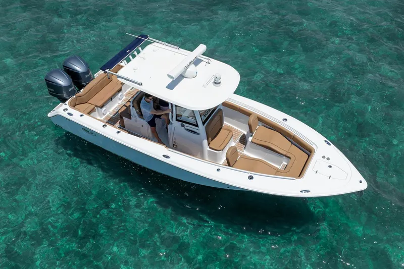 Slide: The Image of 2021 Sea Hunt Ultra 275 SE boat on clear turquoise water, featuring dual engines and spacious seating. - 15