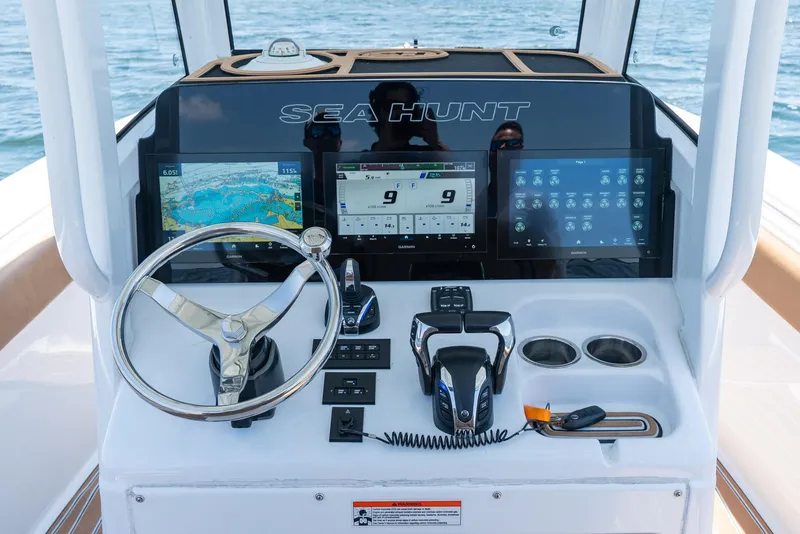 Slide: The Image of 2021 Sea Hunt Ultra 275 SE dashboard with steering wheel, navigation screens, and controls. - 18