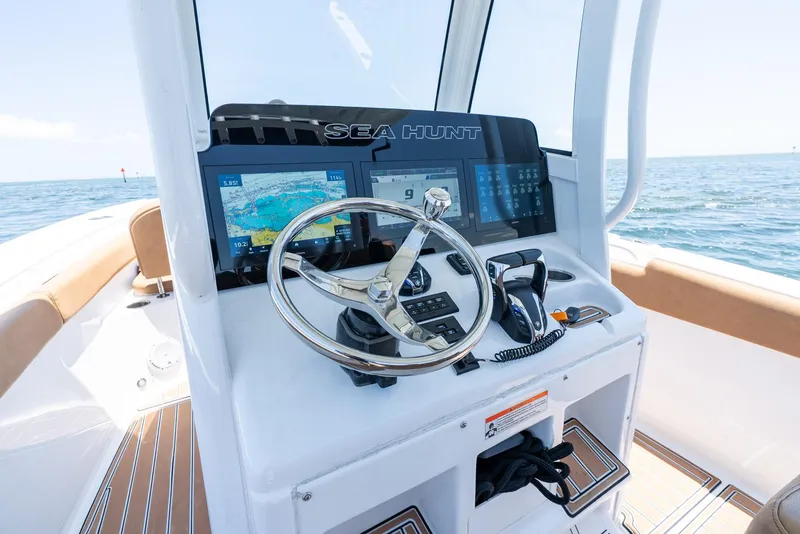 Slide: The Image of 2021 Sea Hunt Ultra 275 SE boat dashboard with steering wheel and navigation screens. - 21