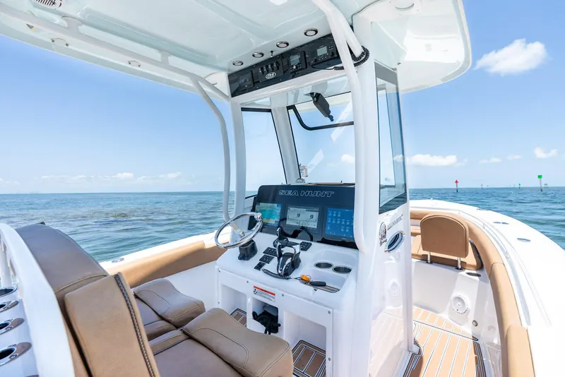 Slide: The Image of 2021 Sea Hunt Ultra 275 SE boat interior with helm, ocean view, and clear sky. - 22