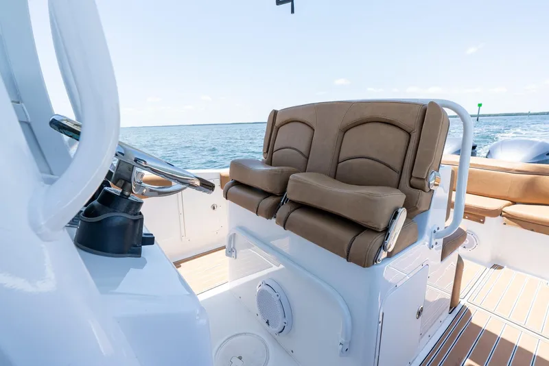 Slide: The Image of 2021 Sea Hunt Ultra 275 SE boat interior with brown seating and ocean view. - 25