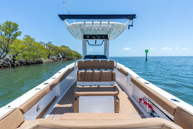 Slide: The Image of 2021 Sea Hunt Ultra 275 SE boat on calm water, featuring spacious seating and sleek design. - 27