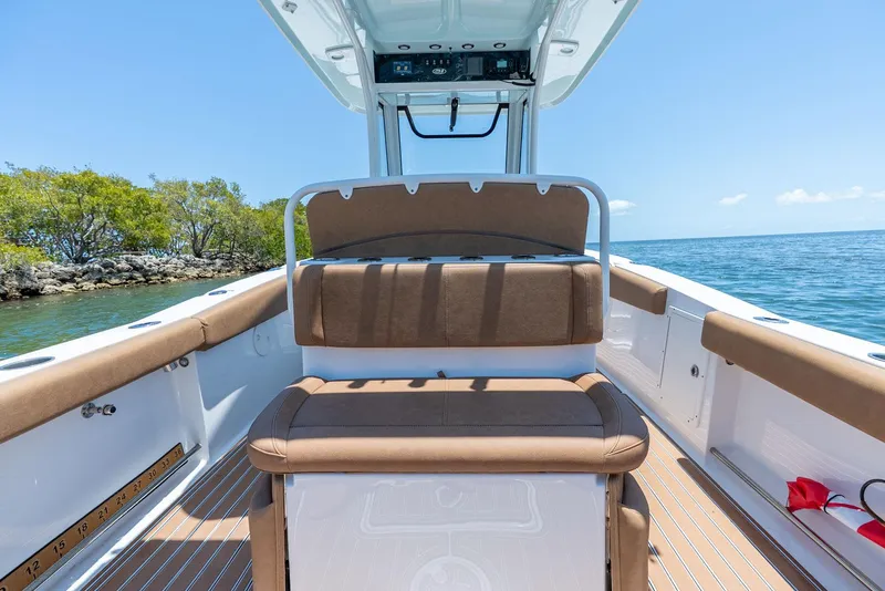 Slide: The Image of 2021 Sea Hunt Ultra 275 SE boat interior with cushioned seating, ocean view, and clear sky. - 28