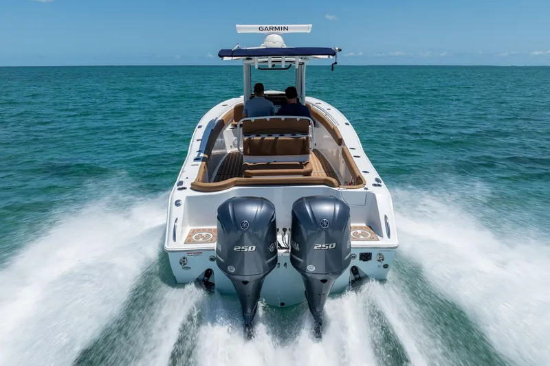 Slide: The Image of 2021 Sea Hunt Ultra 275 SE boat cruising on open water, rear view. - 7