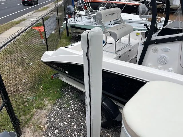 Slide: The Image of 2004 Hurricane FD196RE boat parked near a fence on gravel. - 11