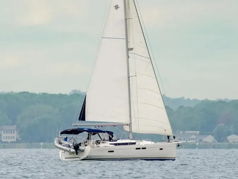 Slide: The Image of 2016 Jeanneau Sun Odyssey 479 sailing on calm waters with lush shoreline background. - 2