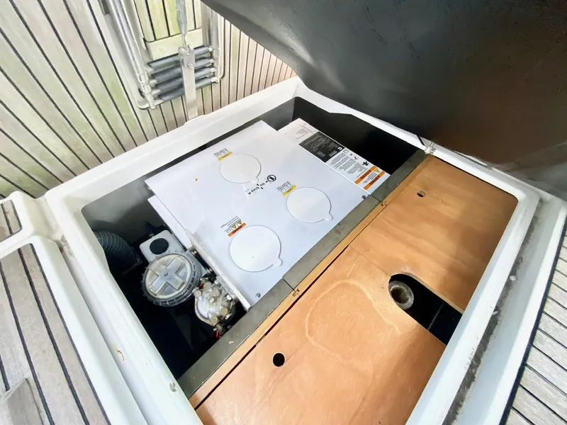 Slide: The Image of Storage compartment on a 2016 Jeanneau Sun Odyssey 479 sailboat, featuring equipment and wooden panel. - 46