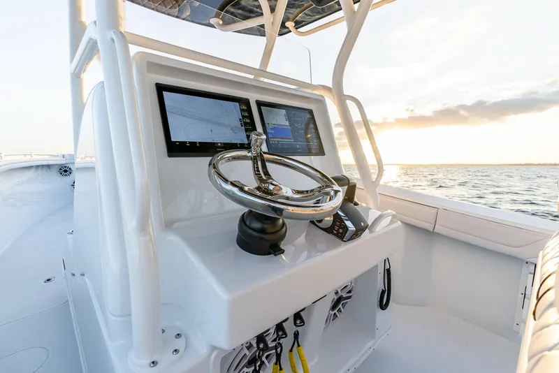 Slide: The Image of 2023 Yellowfin 34 boat console with dual screens and steering wheel at sunset. - 15