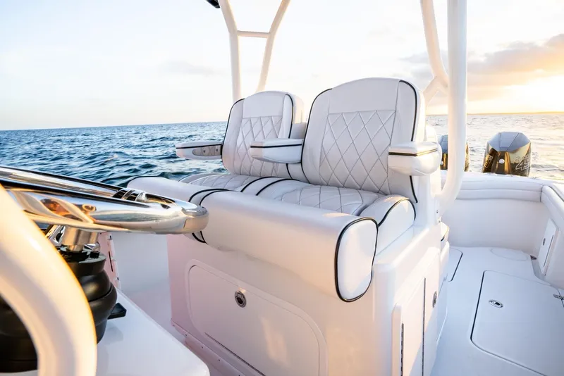 Slide: The Image of 2023 Yellowfin 34 boat interior with luxurious seating, ocean view, and sunset. - 17