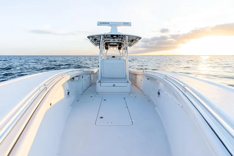 Slide: The Image of 2023 Yellowfin 34 boat on open sea at sunset, showcasing sleek design and spacious deck. - 19