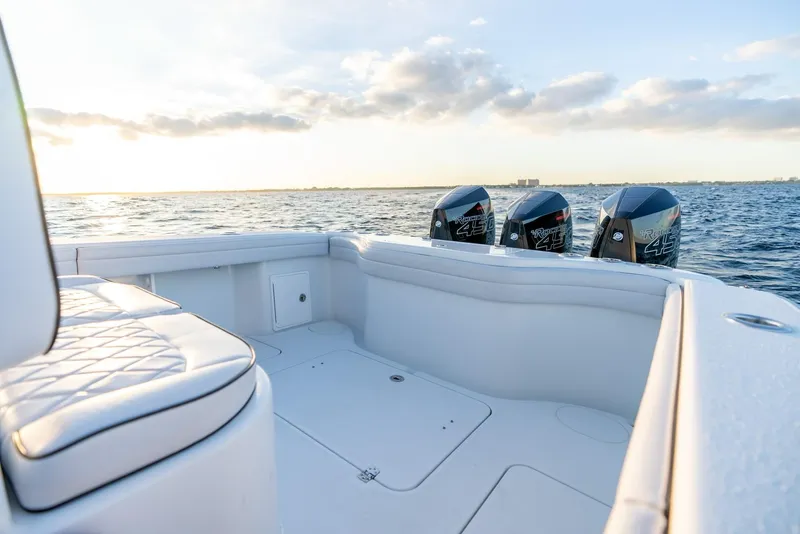Slide: The Image of 2023 Yellowfin 34 boat with triple outboard engines on open water at sunset. - 23