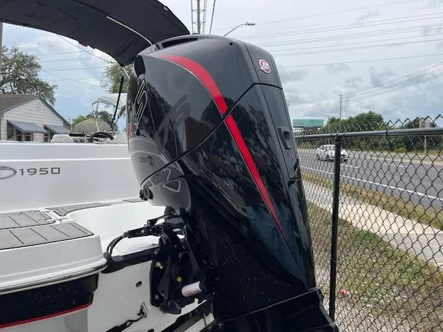 Slide: The Image of Tahoe 1950 boat with powerful outboard motor, 2023 model, parked near a chain-link fence. - 3