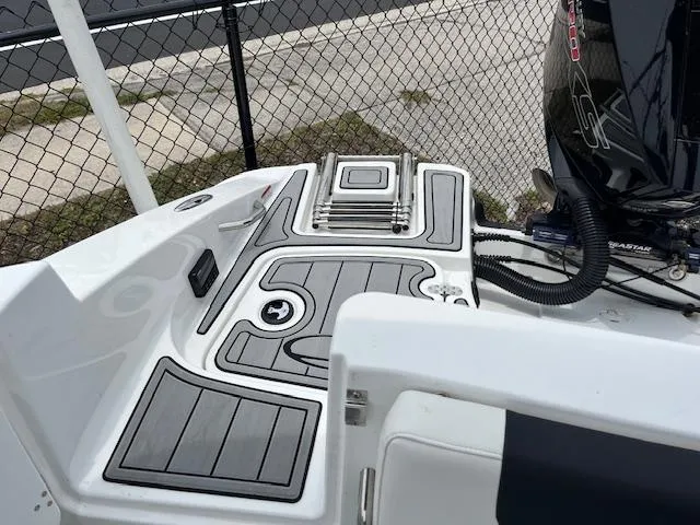 Slide: The Image of 2023 Tahoe 1950 boat deck with ladder and motor, near a chain-link fence. - 6