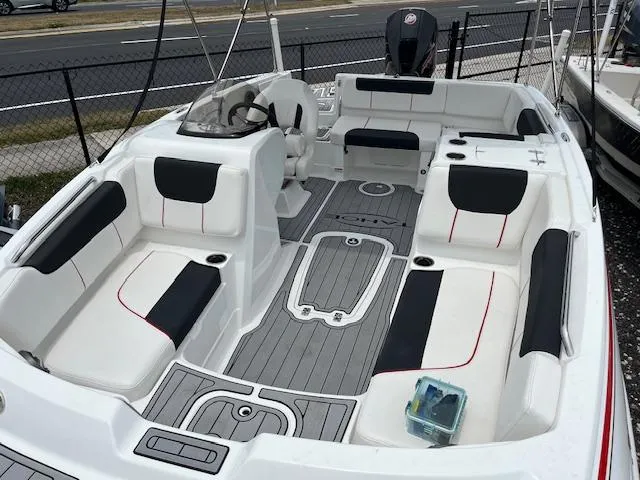 Slide: The Image of 2023 Tahoe 1950 boat interior with seating and steering wheel, docked near a road. - 9