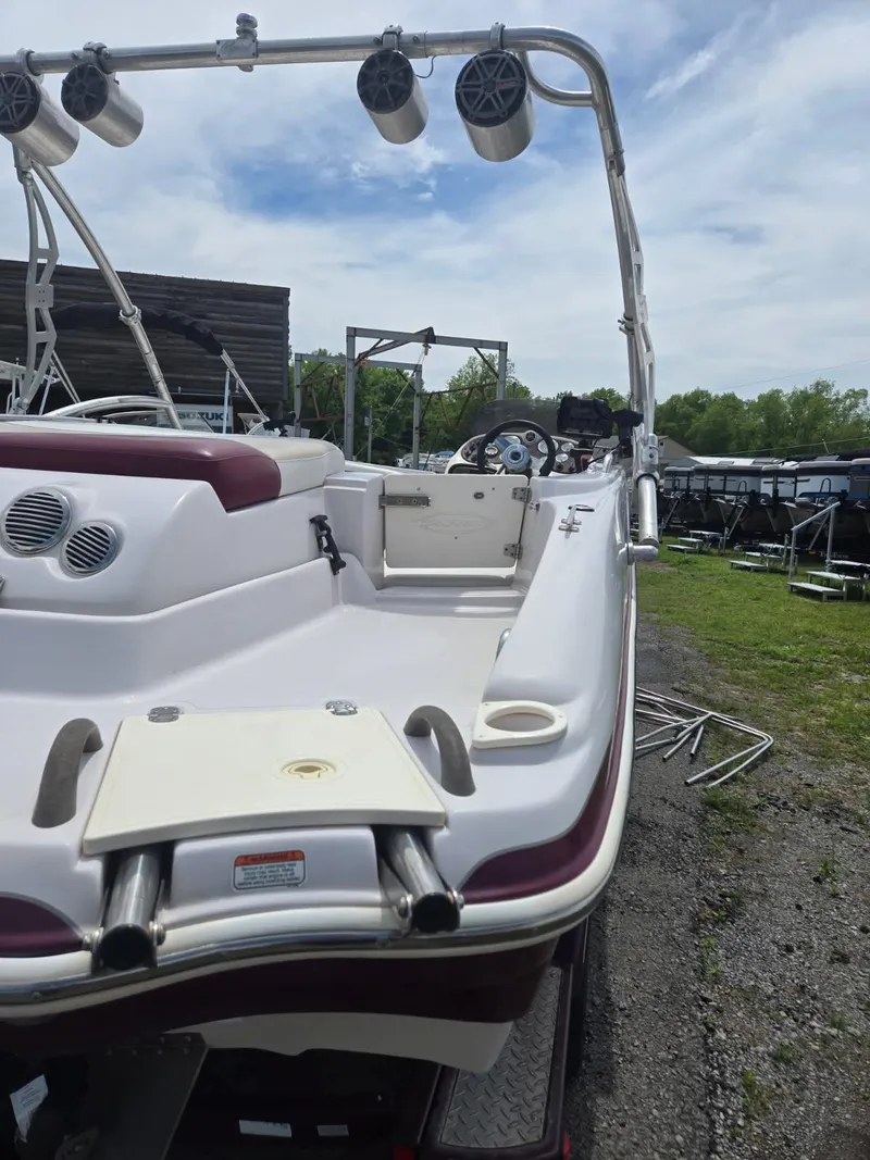 Slide: The Image of 2008 Tahoe 215 I/O boat with speakers and seating, parked outdoors. - 10