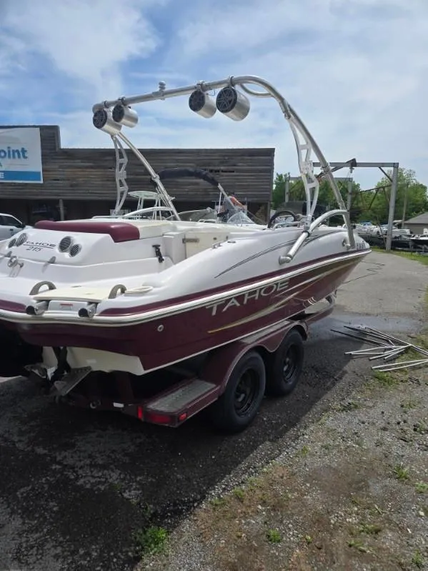 Slide: The Image of 2008 Tahoe 215 I/O boat on trailer, parked outdoors, with wakeboard tower and speakers. - 2