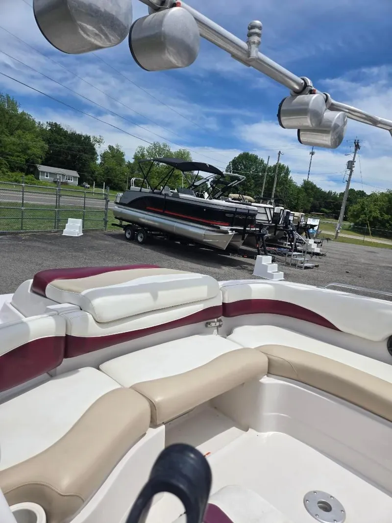 Slide: The Image of 2008 Tahoe 215 I/O boat interior with seating, parked boats in background. - 6