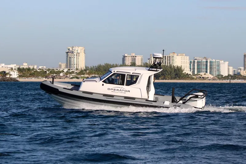 Slide: The Image of 2022 Fluid Watercraft Patrol 880 Cabin boat cruising near city skyline. - 4
