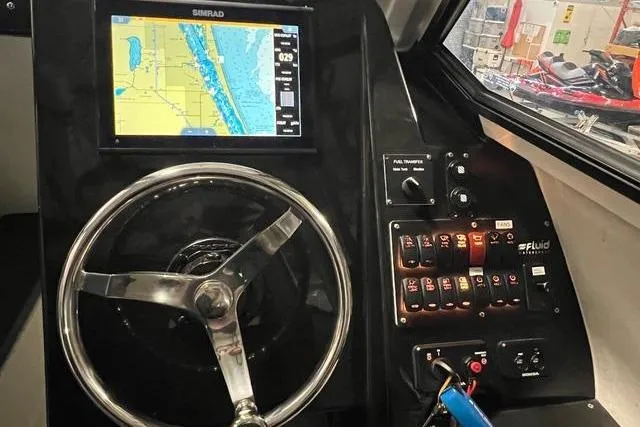 Slide: The Image of Control panel of 2022 Fluid Watercraft Patrol 880 Cabin with navigation display and steering wheel. - 7