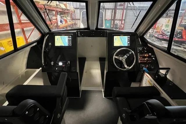 Slide: The Image of 2022 Fluid Watercraft Patrol 880 Cabin interior with navigation screens and steering wheel. - 8