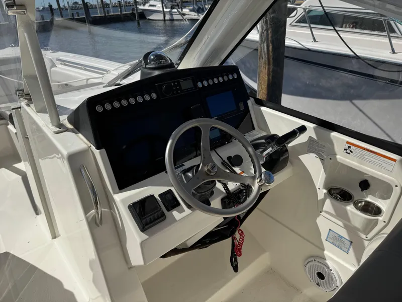 Slide: The Image of Cockpit of 2020 World Cat 280 DC-X boat with steering wheel and control panel. - 11