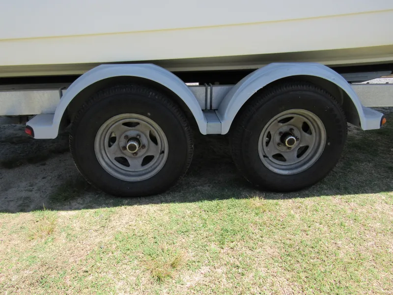 Slide: The Image of Trailer wheels of a 2013 Boston Whaler 200 Dauntless boat on grass. - 10