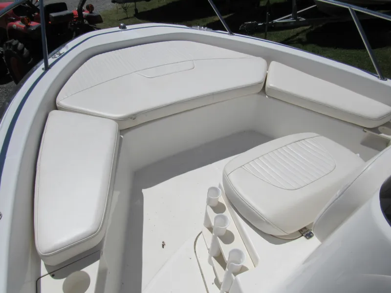Slide: The Image of 2013 Boston Whaler 200 Dauntless boat interior with white cushioned seating and cup holders. - 12