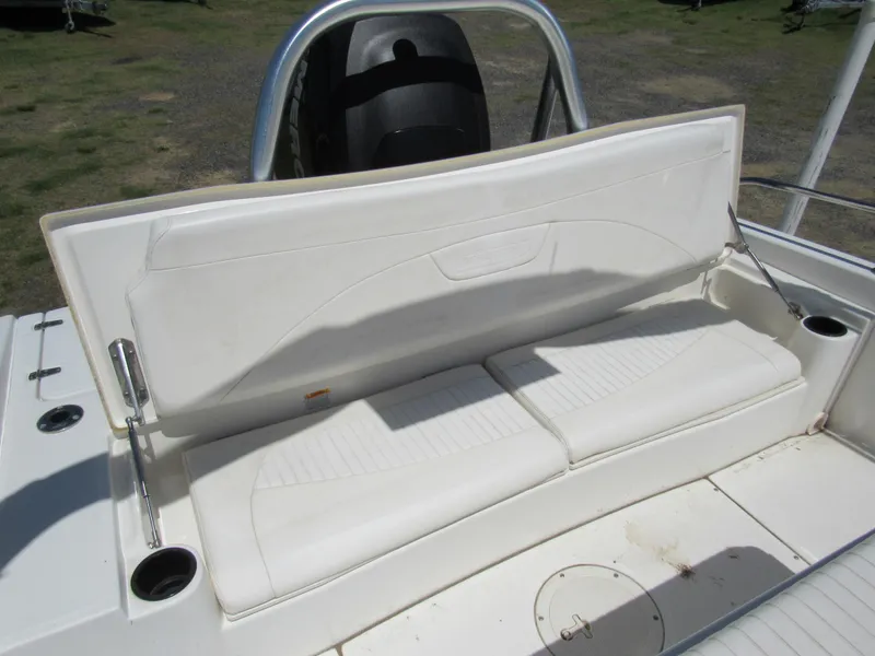 Slide: The Image of 2013 Boston Whaler 200 Dauntless boat seat, white upholstery, cup holders, outdoor setting. - 17