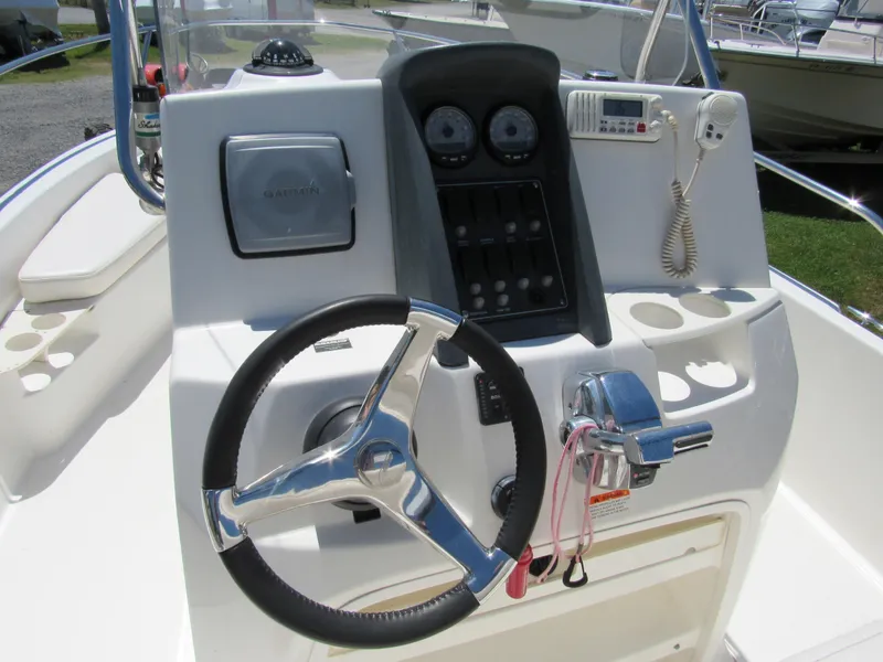 Slide: The Image of Control panel of a 2013 Boston Whaler 200 Dauntless boat, featuring steering wheel and gauges. - 19