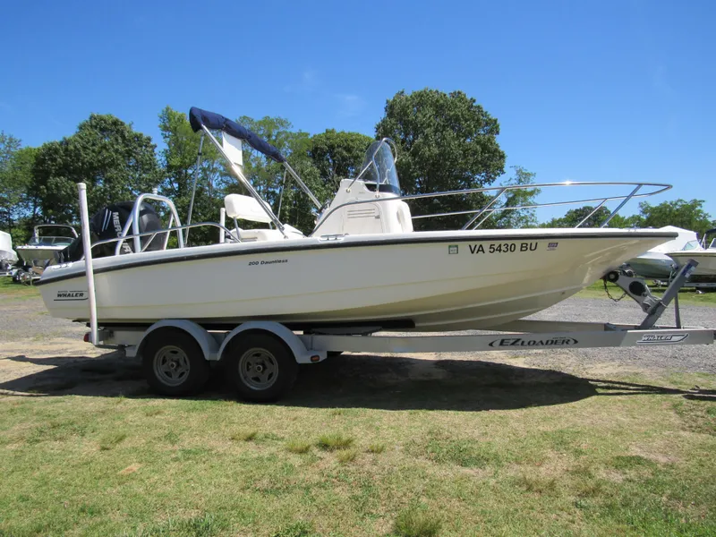 Slide: The Image of 2013 Boston Whaler 200 Dauntless boat on trailer, parked outdoors. - 2