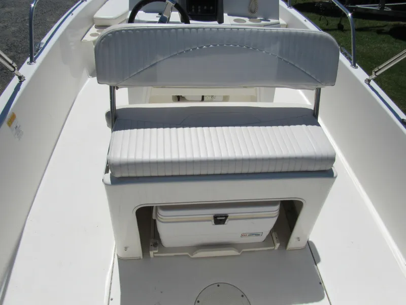 Slide: The Image of 2013 Boston Whaler 200 Dauntless boat interior with cushioned seating and storage compartment. - 20