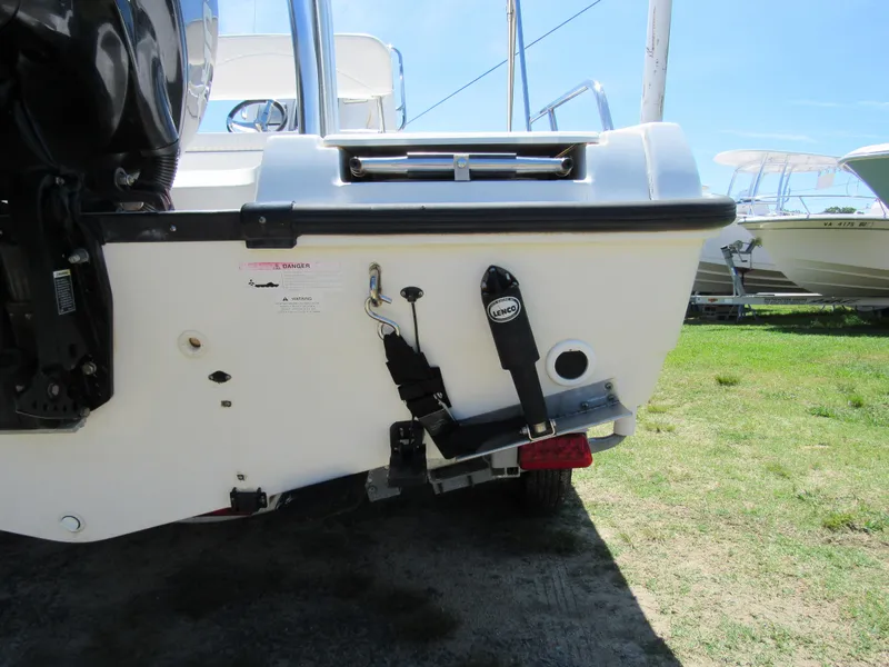 Slide: The Image of 2013 Boston Whaler 200 Dauntless boat stern view, showcasing engine mount and trim tabs. - 5