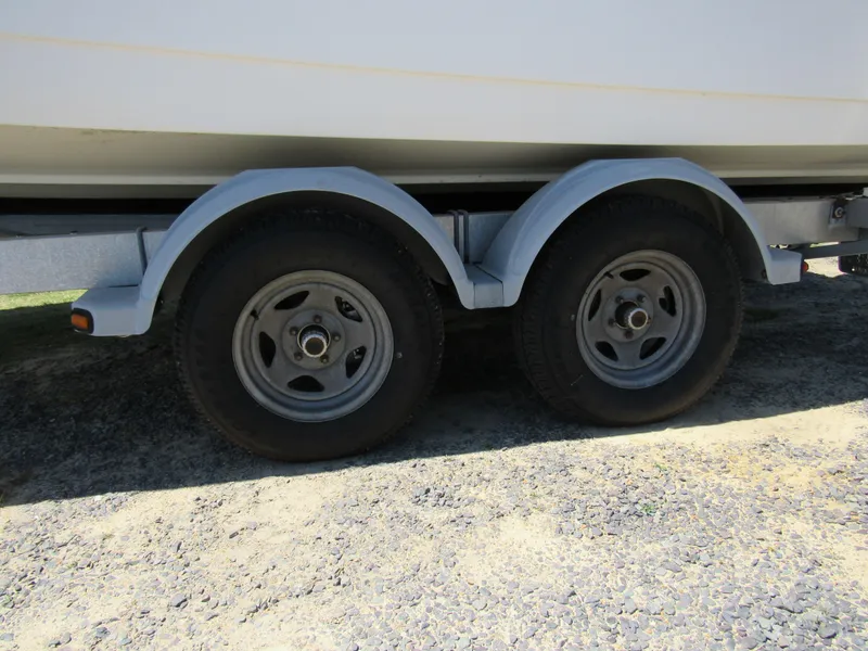Slide: The Image of Trailer wheels of a 2013 Boston Whaler 200 Dauntless boat on gravel. - 9