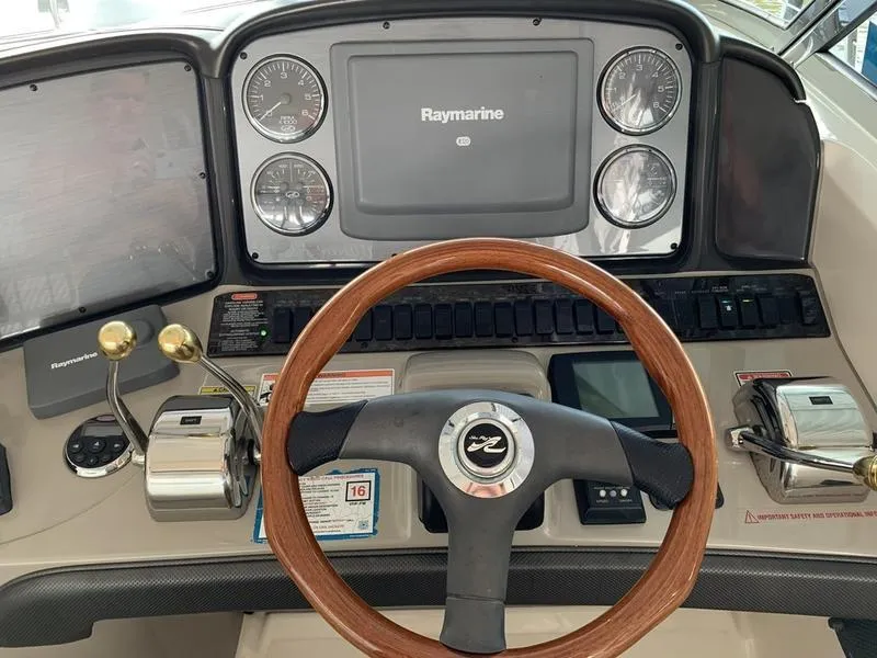 Slide: The Image of 2007 Sea Ray 40 Sundancer helm with Raymarine display and wooden steering wheel. - 18