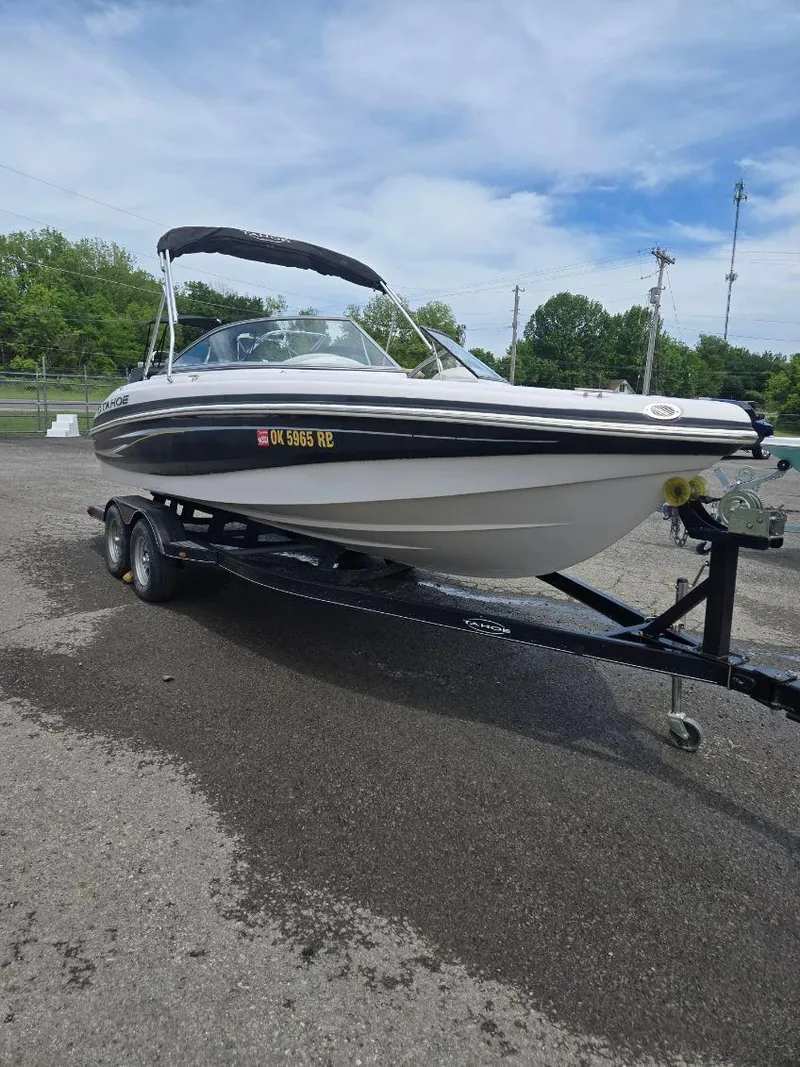 Slide: The Image of 2012 Tahoe Q8 SSi boat on trailer, parked outdoors under a cloudy sky. - 44