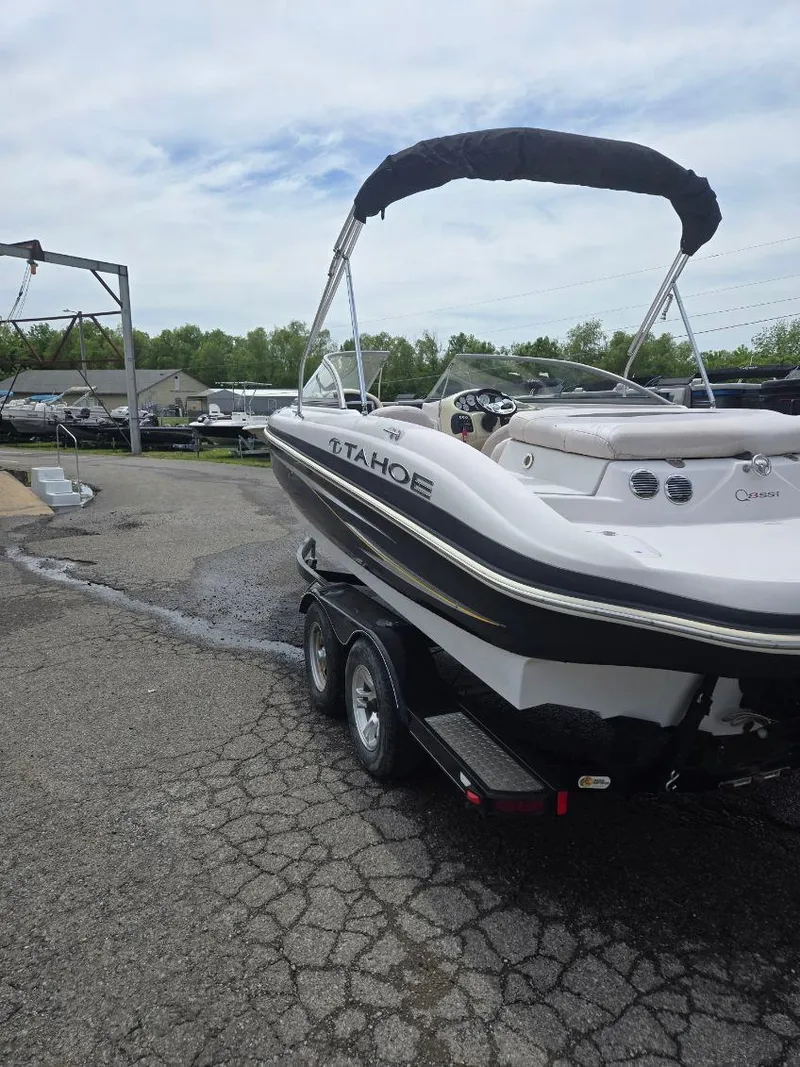 Slide: The Image of 2012 Tahoe Q8 SSi boat on trailer, parked outdoors with canopy. - 47