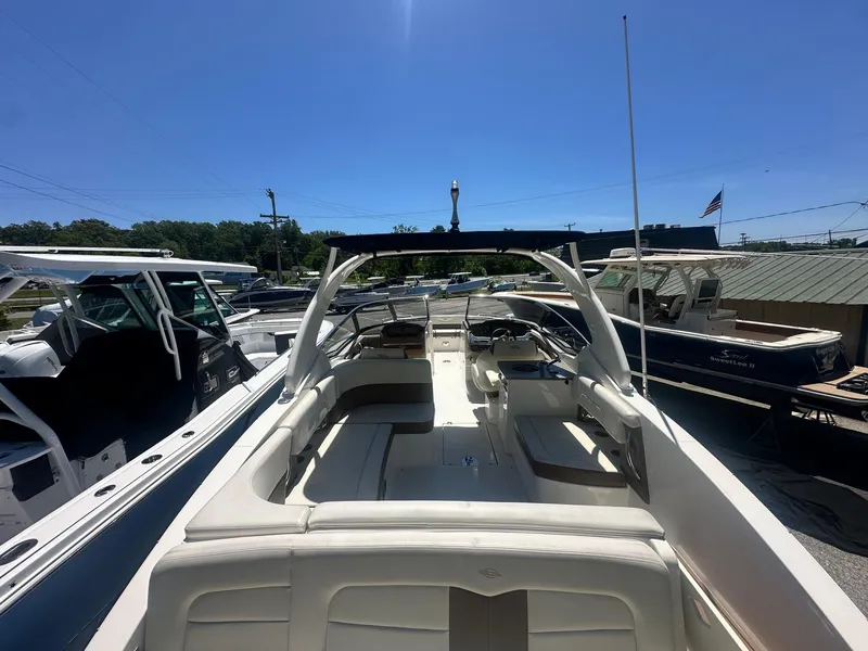 Slide: The Image of 2014 Chaparral 307 SSX boat with spacious seating and sleek design in a marina setting. - 13