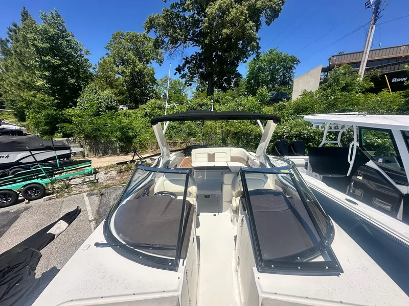 Slide: The Image of 2014 Chaparral 307 SSX boat with open deck, surrounded by greenery and other boats. - 28