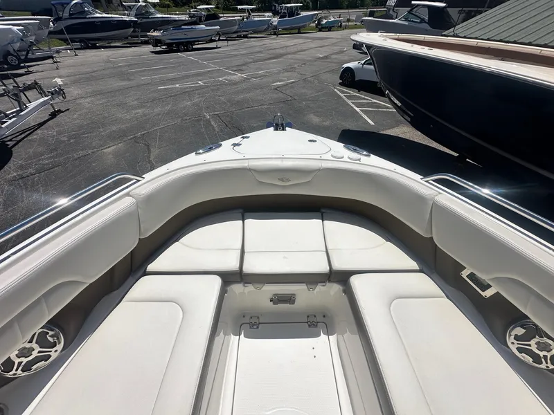 Slide: The Image of 2014 Chaparral 307 SSX boat interior with white seating in a marina setting. - 34