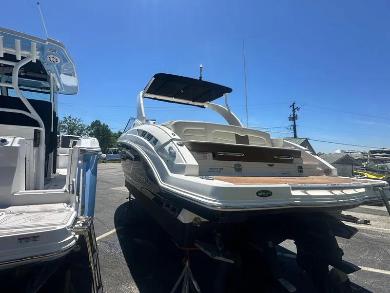 Slide: The Image of 2014 Chaparral 307 SSX boat displayed outdoors under clear blue sky. - 4
